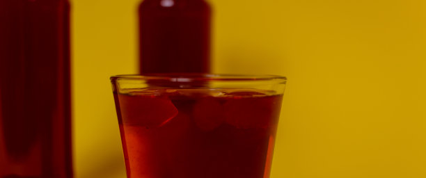 套瓶和玻璃杯，与彩色液体，冰块，饮料，酒精，鸡尾酒，马提尼在彩色背景。图片下载