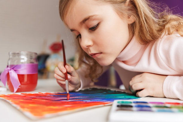 可爱的小女孩在桌子上画画图片下载