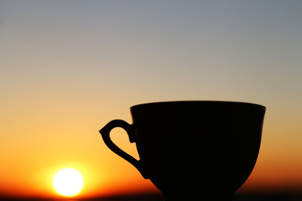 日出背景上咖啡杯的黑色剪影图片下载