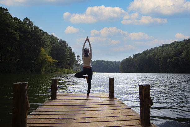 年轻健康的女人在大自然的桥上练习瑜伽图片下载