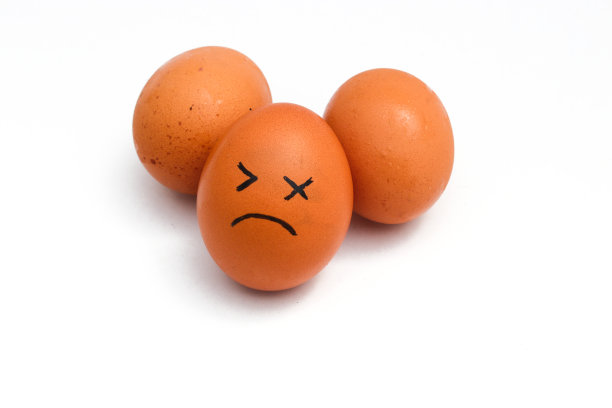 一群棕色的鸡蛋，白色背景上孤立着疲惫的面孔。图片下载