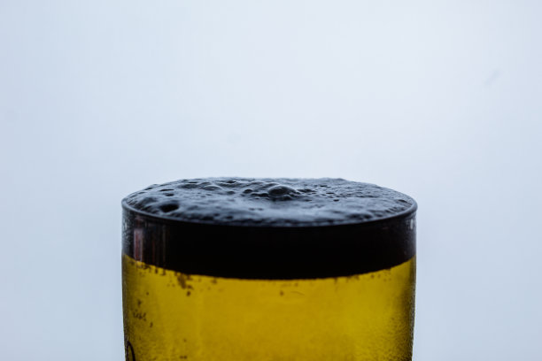 有泡沫的啤酒杯的顶部图片下载