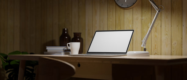 黑暗的家庭工作室，开放式的笔记本电脑，台灯，夜间工作的概念图片下载