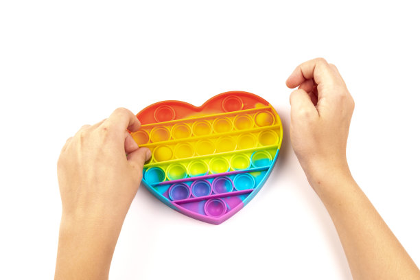 硅现代玩具抗压力popit将是一个心形的白色背景。玩具pop it或简单的酒窝。图片下载