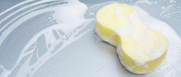 黄色海绵和肥皂覆盖汽车清洗。发动机罩清洁。概念洗车清洁。留出书写信息的空间。图片下载