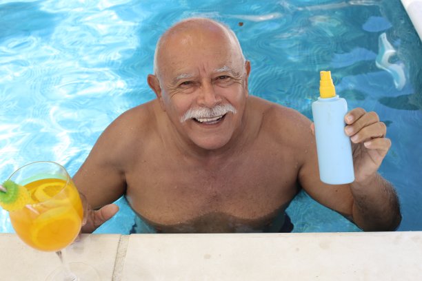 一名老人在游泳池里拿着防晒霜图片下载