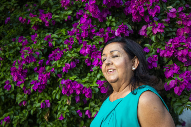 一个老妇人在一棵布甘维利亚树下图片下载