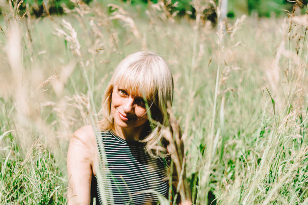 夏天的肖像成熟的成年金发女人坐在草地上阳光灿烂的一天图片下载