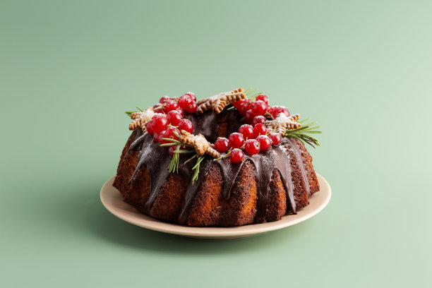 美味的圣诞和新年派与巧克力和浆果坚实的绿色背景。为文本、模板复制空间图片下载