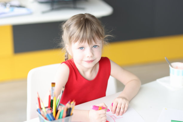 小女孩用彩色铅笔在纸上画画图片下载