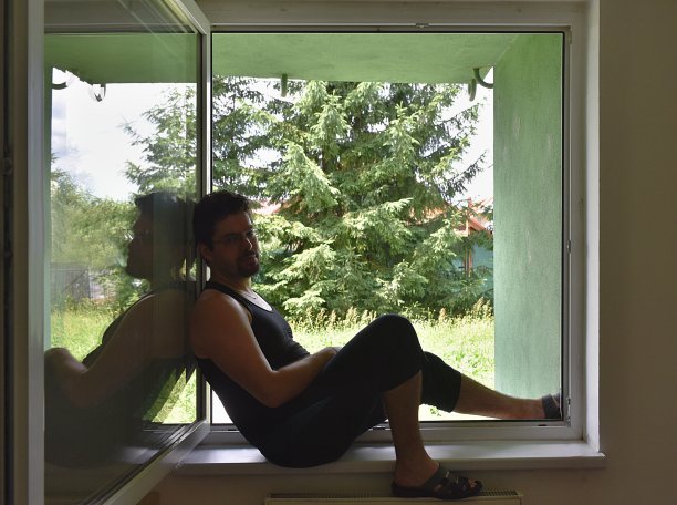 一个人坐在窗边降温。公寓在炎热的天气，没有空调图片下载