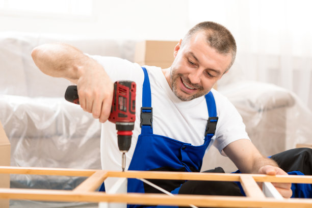 快乐工匠在室内用钻具固定木柜图片下载