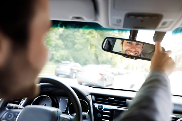 穿着西装手握方向盘的白人，配置了镜子图片下载