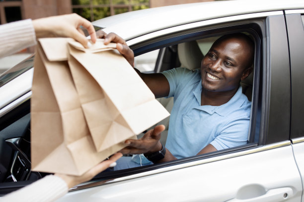 快乐的非裔美国人司机拿着纸袋图片下载