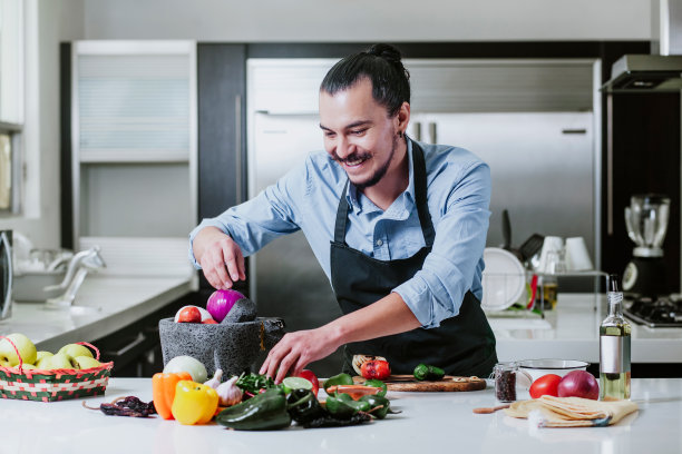 墨西哥城，一名拉丁男子在家做饭，在厨房里准备沙拉或墨西哥酱汁图片下载