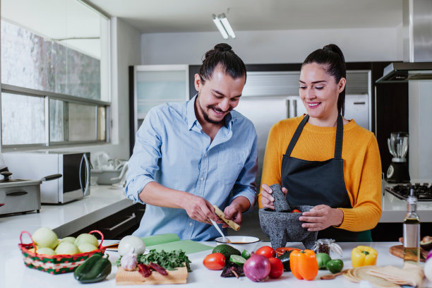 一对拉丁夫妇在墨西哥城家中的厨房里一起做墨西哥酱图片下载