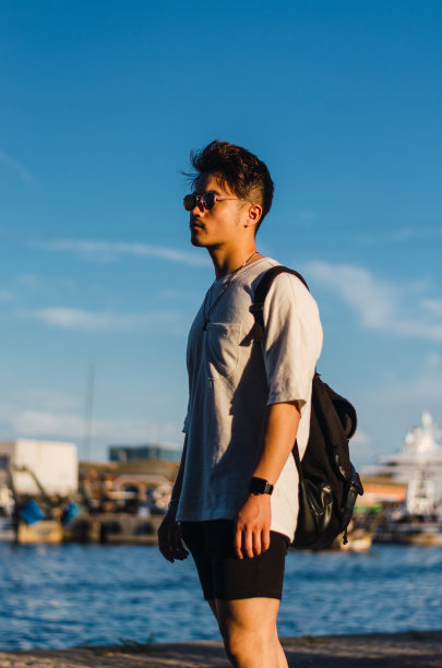 年轻英俊的中国男子在巴塞罗那港口和大海前的画像图片下载