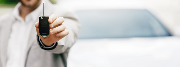 在车展上成功交易后，年轻的男顾问将车钥匙交给买家的照片图片下载