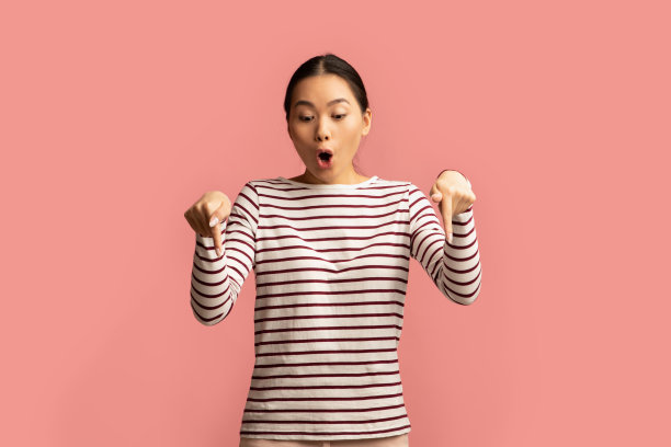 神奇的报价。震惊的亚洲女性用两根手指向下指图片下载