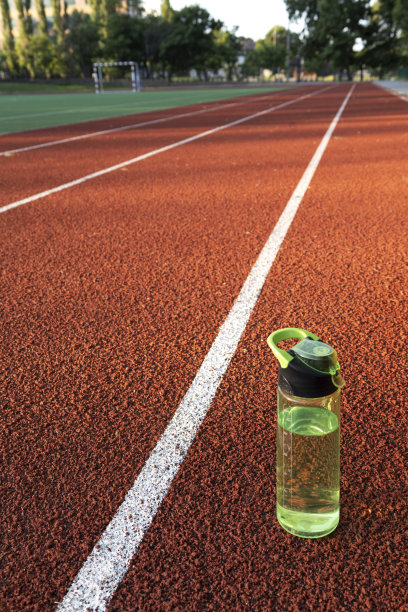 垂直形象的红色太阳路和瓶装水在体育场图片下载