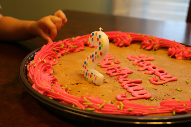 孩子摸着大的生日饼干上的糖霜图片下载