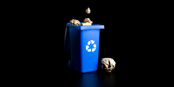 分离回收。蓝色垃圾桶用于回收废纸，隔离在黑色背景上。垃圾箱容器用于处理垃圾废物，节约环境。图片下载