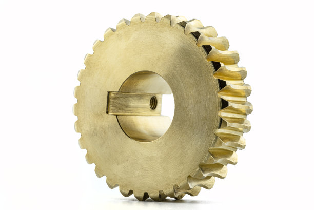 一个新的闪光铜齿轮的微距照片，孤立在白色的背景上，可见的孔为锁定螺钉。图片下载