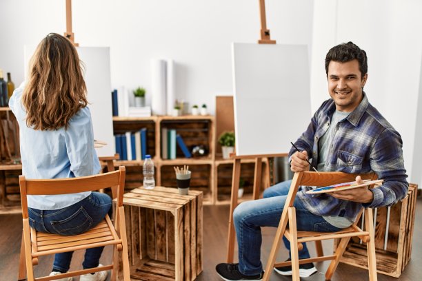 两个西班牙学生微笑着在艺术学校愉快地绘画。图片下载