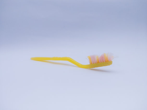 白色背景上的黄色旧牙刷图片下载