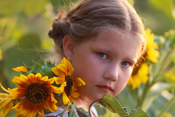 美丽快乐的女孩与向日葵一起享受大自然，欢笑着夏日向日葵田。阳光，阳光，灿烂的太阳。高质量的照片。图片下载