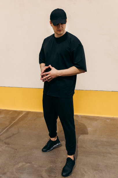 穿着黑色t恤和黑色棒球帽的男人，上面有你的标志或设计的空间。模拟了图片下载