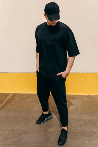 穿着黑色t恤和黑色棒球帽的男人，上面有你的标志或设计的空间。模拟了图片下载