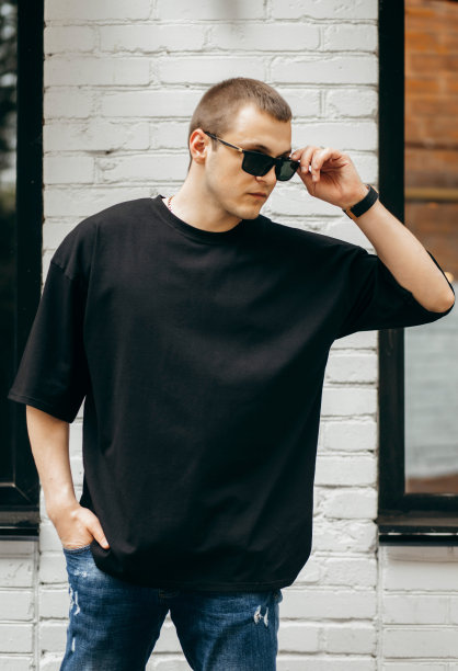 男人穿着黑色的空白t恤，上面有你的标志或设计的空间。模拟了图片下载