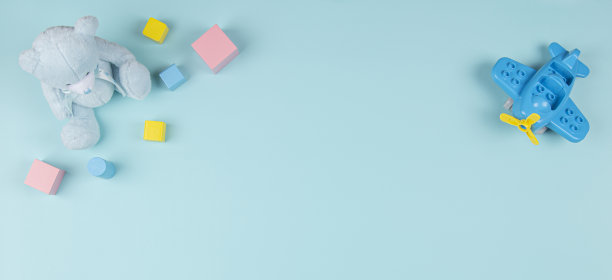 婴儿儿童玩具横幅背景。泰迪熊，塑料建筑飞机，木块浅蓝色背景。俯视图，平铺，复制空间图片下载