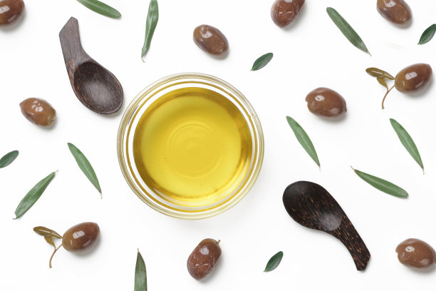 俯视图特级初榨橄榄油在碗和橄榄孤立在白色背景。图片下载