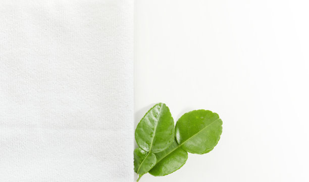 新鲜的佛手柑叶和白色背景的毛巾图片下载