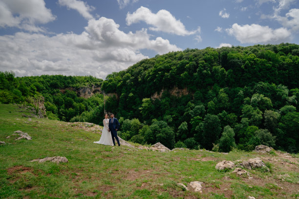 美丽的新婚夫妇在山林的背景下。婚礼在山脉。图片下载