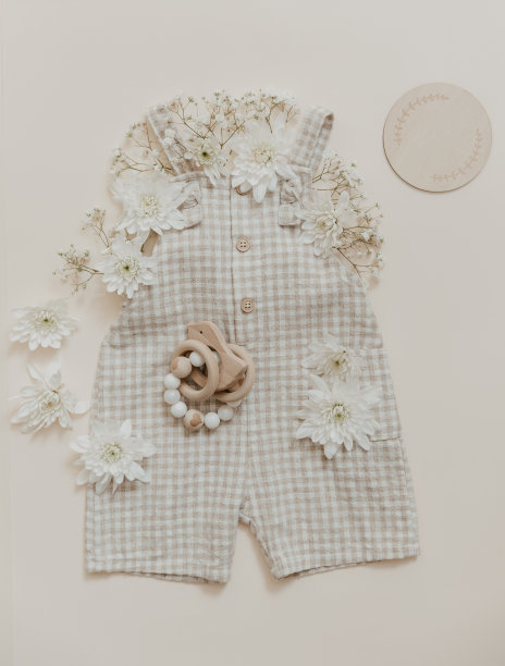 带花的柔软婴儿裤。时尚新生，波西米亚风格，中性米色。平铺，俯视图。天然纺织品，粉彩背景。图片下载