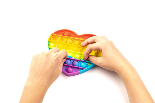 硅现代玩具抗压力popit将是一个心形的白色背景。玩具pop it或简单的酒窝。图片下载