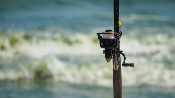 海滩上的鱼竿。主要焦点在右边的杆，复制空间在左边。图片下载