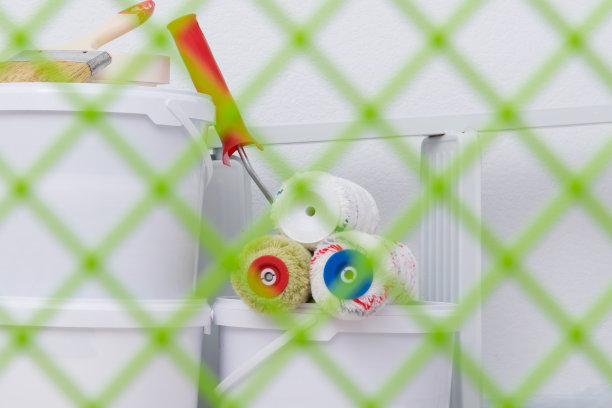 照片背景，通过一个分配油漆的网格，在一个滚筒和刷子，一套着色工具图片下载