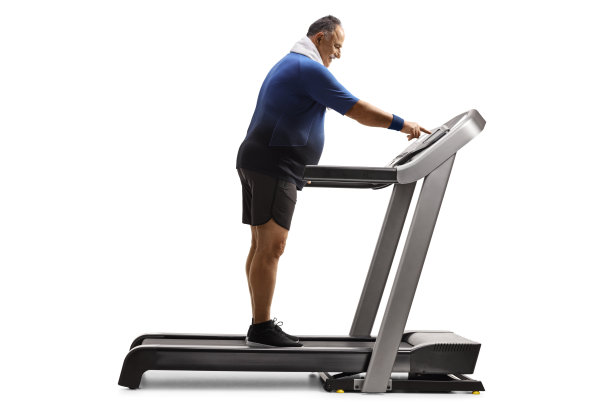 中年男人推动跑步机上的电源开关图片下载