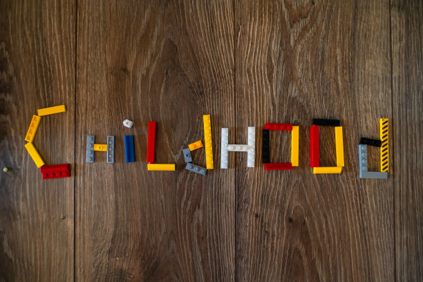 彩色塑料砖，块和细节在木制背景平铺。玩具的小零件零件。童年本空间图片下载