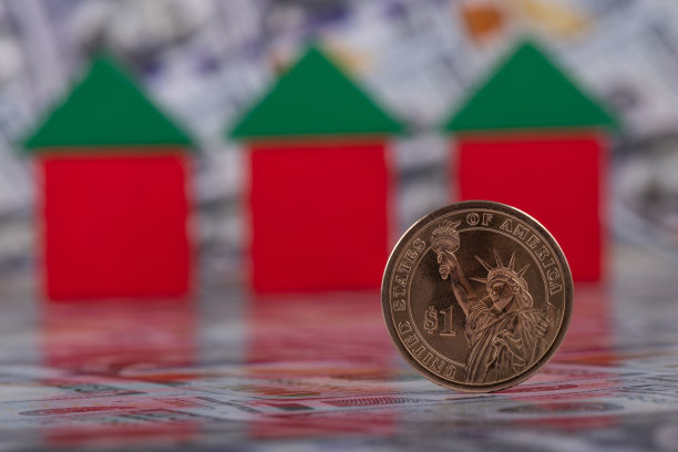 1美元硬币的背景是三个象征性的小房子和100美元纸币图片下载