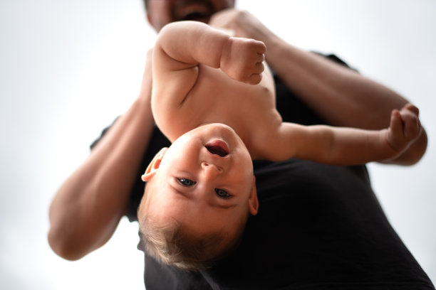 父亲和他的小儿子在屋外玩耍。宝宝看着摄像机。图片下载