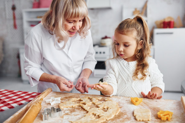 教学过程。老奶奶和她的小孙女在厨房为圣诞节做糖果图片下载