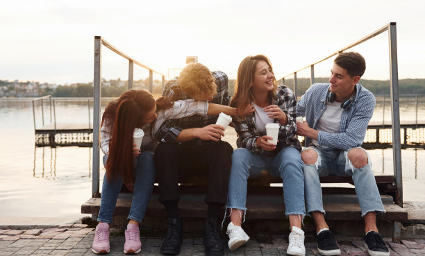 在湖的附近。一群年轻开朗的朋友在户外一起玩图片下载