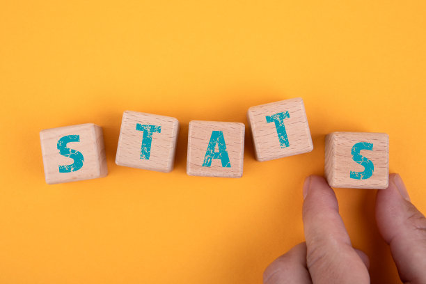 统计数据。黄色背景上的木块和一个男人的手图片下载