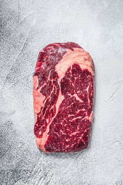 生肋眼牛排放在桌子上准备烤。白色背景。俯视图图片下载