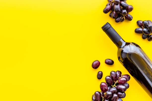 酒厂的背景。一瓶红酒和黑葡萄图片下载